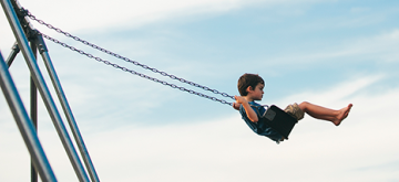 Een kleine jongen op een schommel